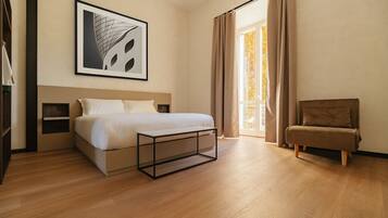 A modern bedroom with a bed, bedside tables, a bench, a chair, and a large window with curtains.