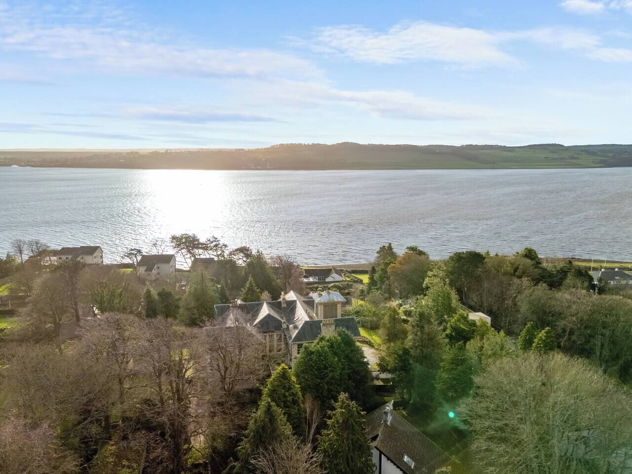 A lakeside property with multiple houses, a dock, and a clear view of the lake.