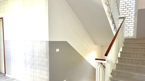 Un escalier avec des rampes en bois et un plancher de couleur claire.
