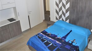 A bedroom with a bed, a wardrobe, a desk, and a nightstand. - Apartment 'Monolocale Eddy By Salentolimit' with Balcony and Air Conditioning (Torre Lapillo)