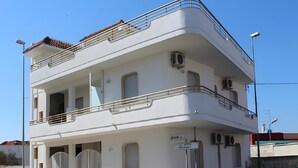 A two-story building with a balcony, air conditioning units, and a gated entrance. - Apartment 'Monolocale Eddy By Salentolimit' with Balcony and Air Conditioning (Torre Lapillo)