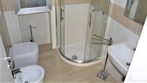 A modern bathroom with a glass-enclosed shower, a bidet, and a sink. - Apartment 'Monolocale Eddy By Salentolimit' with Balcony and Air Conditioning (Torre Lapillo)