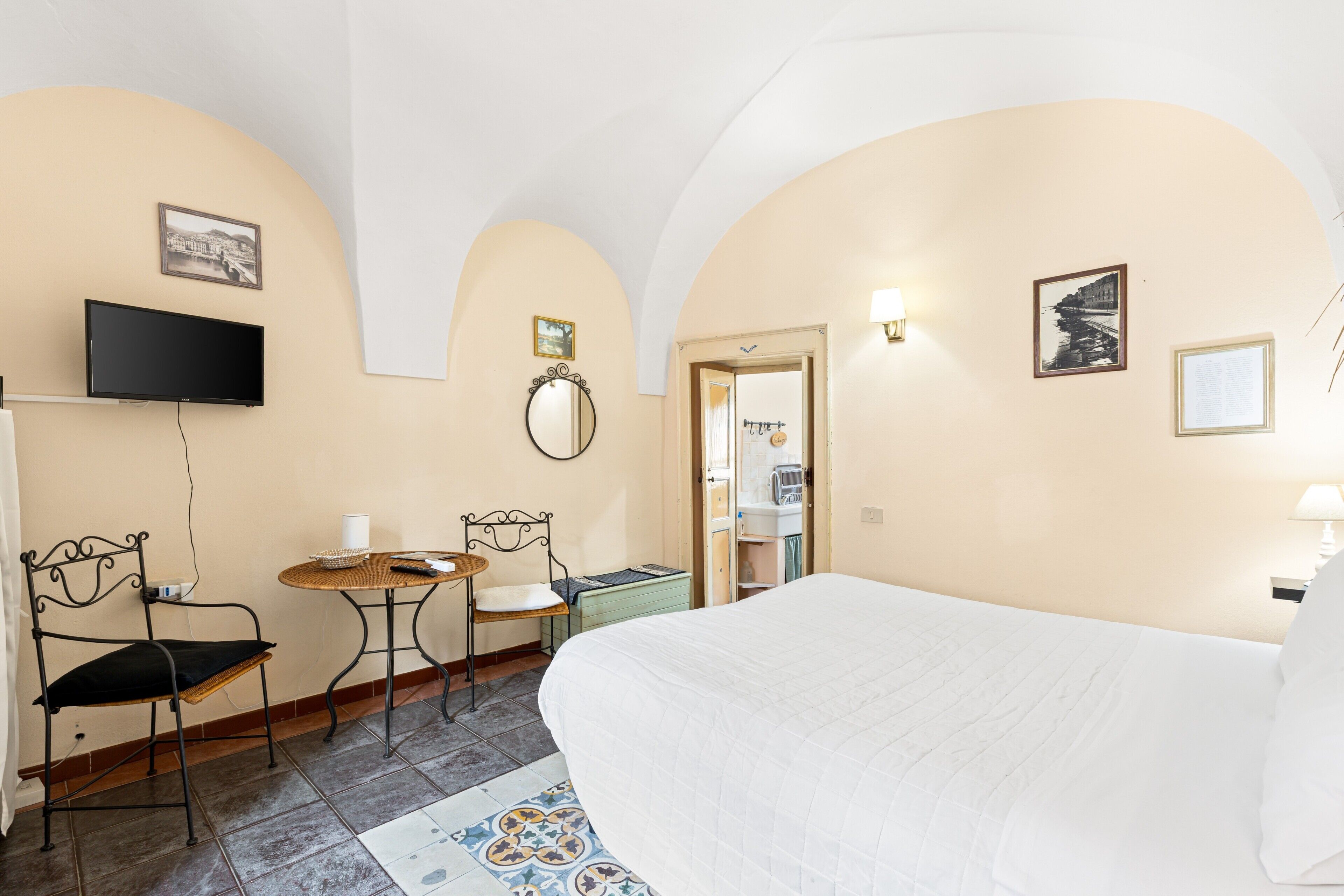 Une chambre d’hôtel comprenant un lit, une télévision, une table à manger et des chaises.