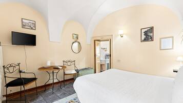 Une chambre d’hôtel comprenant un lit, une télévision, une table à manger et des chaises.