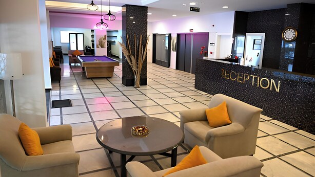 A reception area with a pool table, lounge chairs, and a reception desk. - HOTEL ROXX ROYAL (Kusadasi)