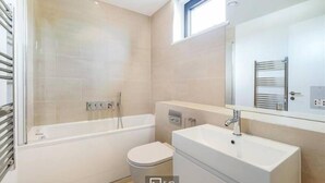 Un baño moderno con bañera, inodoro y lavamanos.