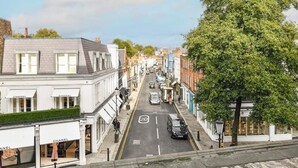A street view with a row of buildings, including a Chanel store on the left. - The Elden - No.4 (London)