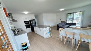 Een modern appartement met keuken, eethoek en woonkamer.