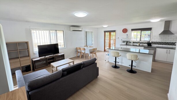 Een modern appartement met een woonkamer, eetgedeelte en keuken.