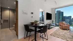 Una sala de estar moderna con comedor, ventanas grandes y vista a la ciudad.
