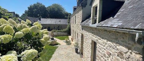 A stone building with a stone pathway leading to a gate.