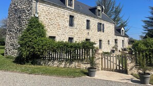 A stone building with a sloped roof, multiple windows, and a gated entrance. - Chambre Raphaël, a jewel in the Bay of Douarnenez, 10 minutes from the beaches (Pouldergat)