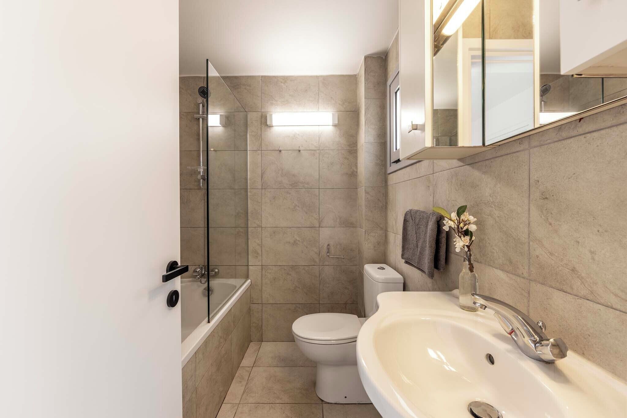A modern bathroom with a bathtub, toilet, and sink.