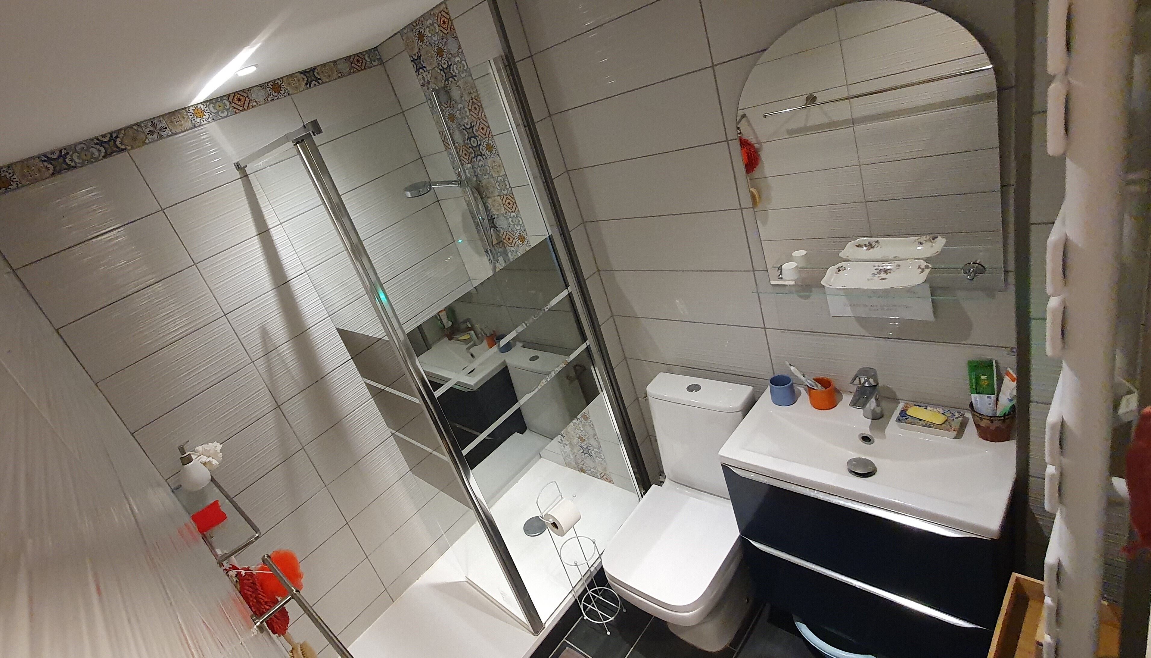 A bathroom with a toilet, sink, and shower area.