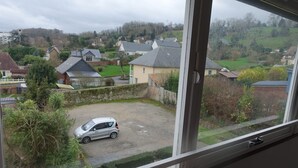 Ett bostadsområde med hus, en bil på en uppfart och en vy genom ett fönster.