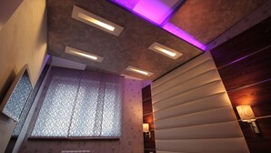 Un intérieur moderne avec un mur à motifs, des spots encastrés au plafond et une lampe décorative fixée au mur.