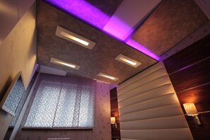 A modern interior with a patterned wall, recessed ceiling lights, and a decorative wall-mounted lamp. - Superior 1-bedroom apartment in Strong Center of Belgrade with Private Garage (Beograd)