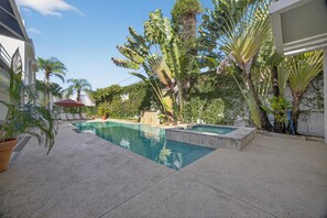 A swimming pool surrounded by tropical plants and a pergola. - Casa Lotus (San Juan)