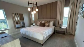 Un dormitorio moderno con una cama grande, mesitas de noche, un espejo y vistas al exterior.