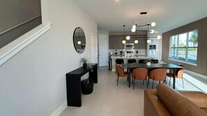 Una cocina moderna con comedor, sofá y un amplio ventanal.