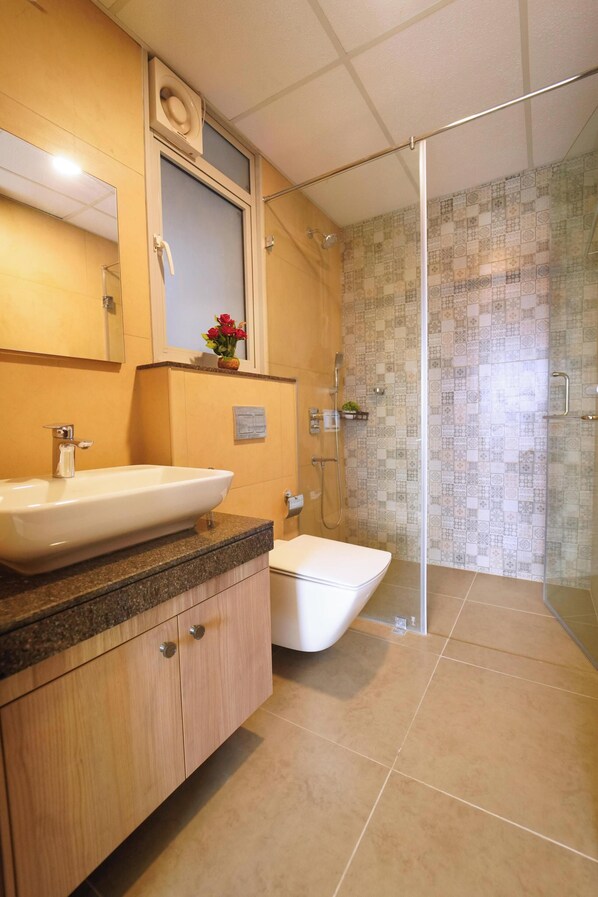 A bathroom with a large sink, a toilet, and a glass shower enclosure. - Auric Blue by Red Olive3bhkomrprime IT Corner (Chennai)