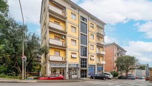 Un edificio de varios pisos con balcones, una tienda CITYSTORE y un restaurante llamado RAHIA.