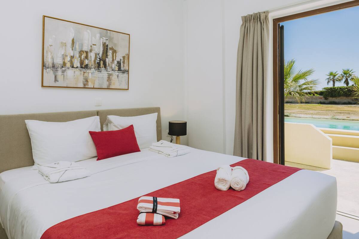 Une chambre d’hôtel avec un lit, un tableau, une vue sur la piscine et un balcon.