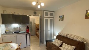 Un espacio habitable pequeño con kitchenette, comedor y sofá.