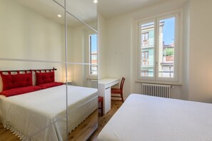 3 dormitorios y tabla de planchar con plancha