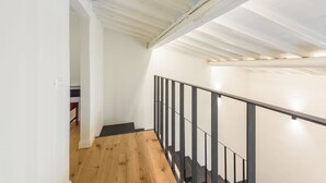 A staircase with a wooden floor and black metal railing, leading to an upper level. - Orcagna by MMega Homes and Villas (Florence)