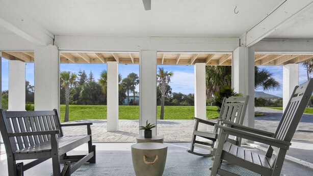 A covered outdoor seating area with benches and a central planter. - Serene Matanzas Beach House Half A Mile to Sand (St. Augustine)