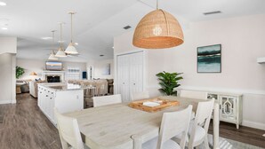 A spacious kitchen with white cabinetry, a central island, and pendant lighting. - Serene Matanzas Beach House Half A Mile to Sand (St. Augustine)