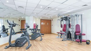 A gym with cardio machines, weightlifting equipment, and a mirrored wall. - Stayshort - Chic Studio in Lago Vista That Sleeps 4 (Dubai)