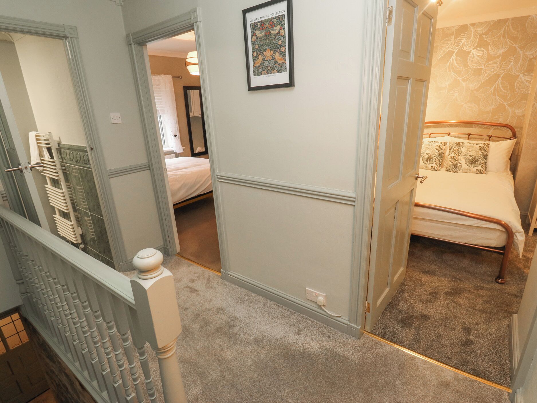 Une chambre à coucher avec un lit, une table de chevet et un tableau accroché au mur.