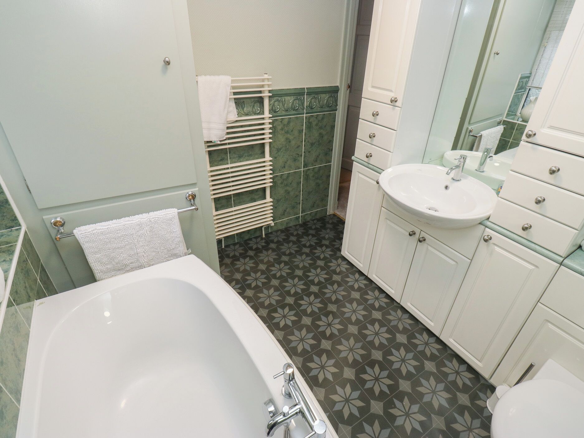 A bathroom with a bathtub, a sink, and a mirror.