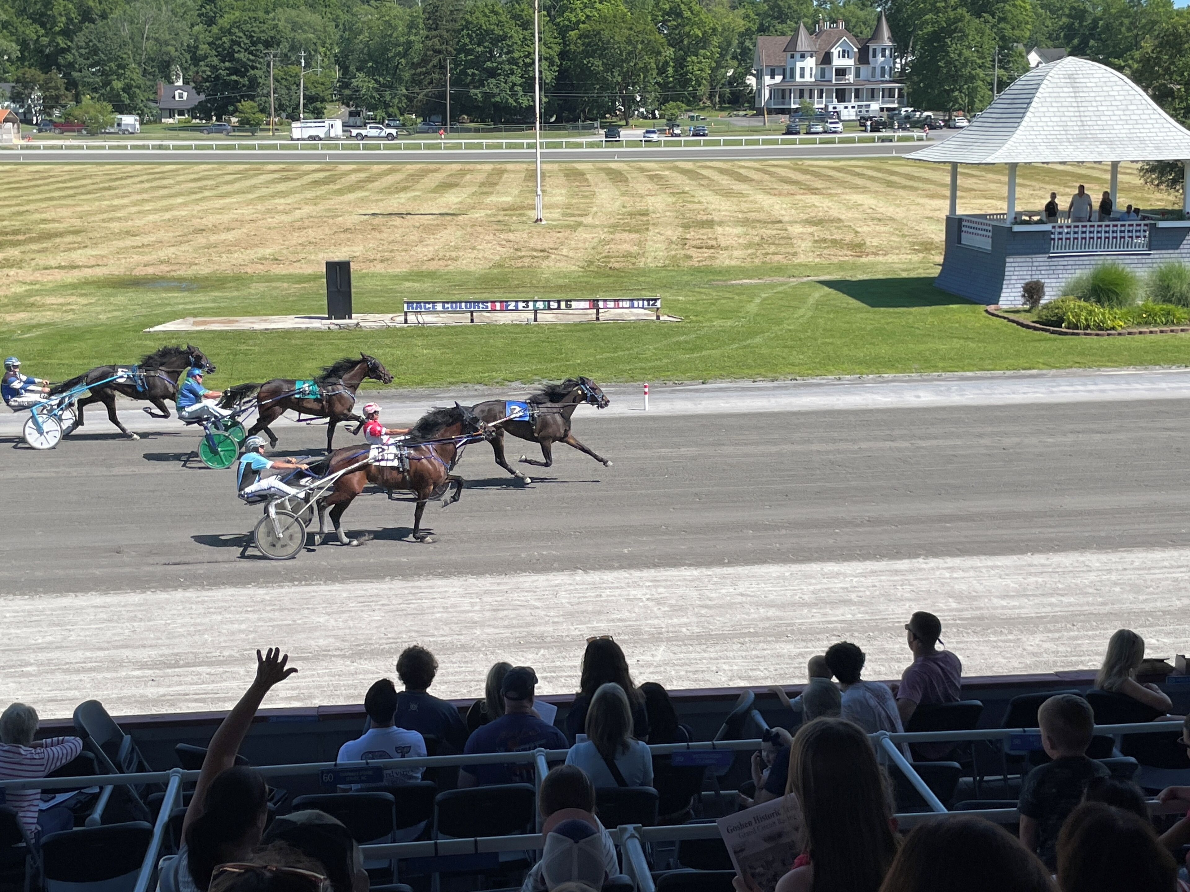 A horse race with spectators in the stands.