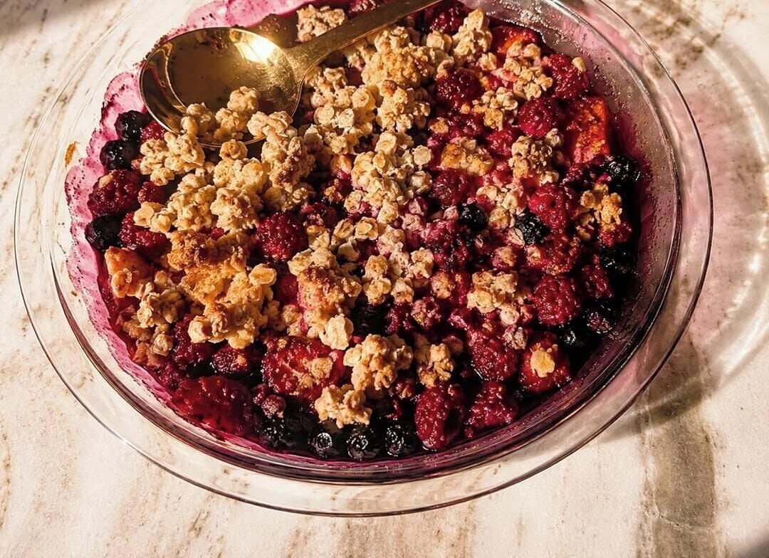 Un bol de crumble aux fruits avec une cuillère.