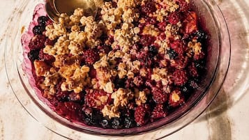 Un bol de crumble aux fruits avec une cuillère.