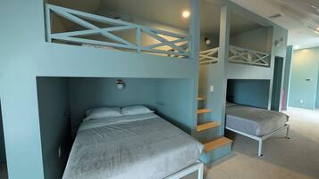 Una habitación con literas, una escalera y una cama.