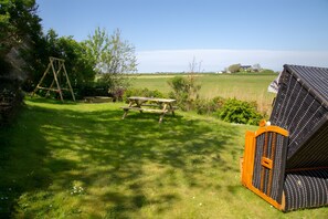 Un espacio al aire libre con césped, una mesa de picnic y un columpio.