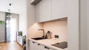 Eine moderne Küche mit weißen Schränken, einer schwarzen Spüle und einem eingebauten Induktionskochfeld.