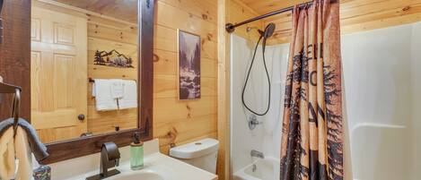 Baño de cabaña de madera con lavamanos, inodoro y ducha.