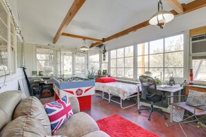 A cozy room with a bed, a desk, a foosball table, and a sofa with a Union Jack pillow. - 18 Mi to Joshua Tree NP: Wfh-ready Desert Escape (Morongo Valley)