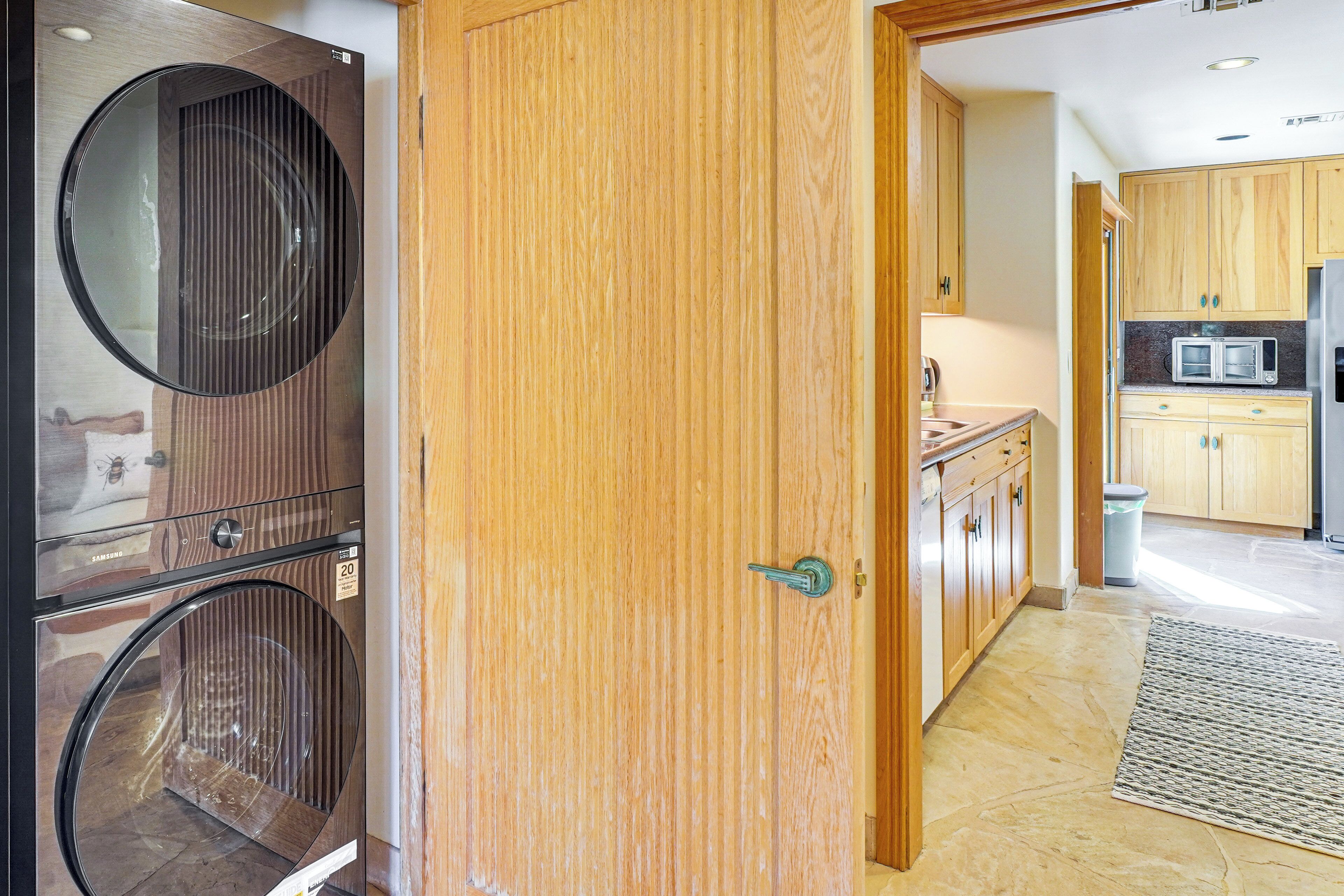 Eine moderne Küche mit Holzschränken, einem Edelstahlkühlschrank und einer Mikrowelle.