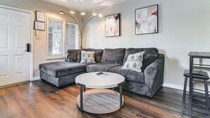 A modern living room with a sectional sofa, a round coffee table, and a bar stool. - Walkable Haven 1 Mi to Dtwn Phoenix & Chase Field! (Phoenix)