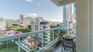 A balcony with a view of a cityscape, including buildings and greenery. - Apts in a Condominium Just 550 Meters From Pereque Beach Etps (Porto Belo)