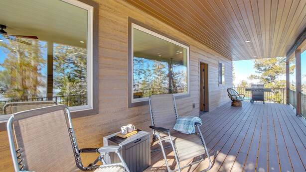 A wooden deck with outdoor seating, a grill, and large windows offering views of trees and a clear sky. - 5 Mins to Brian Head Resort: Family Gem w/ Views (Brian Head)