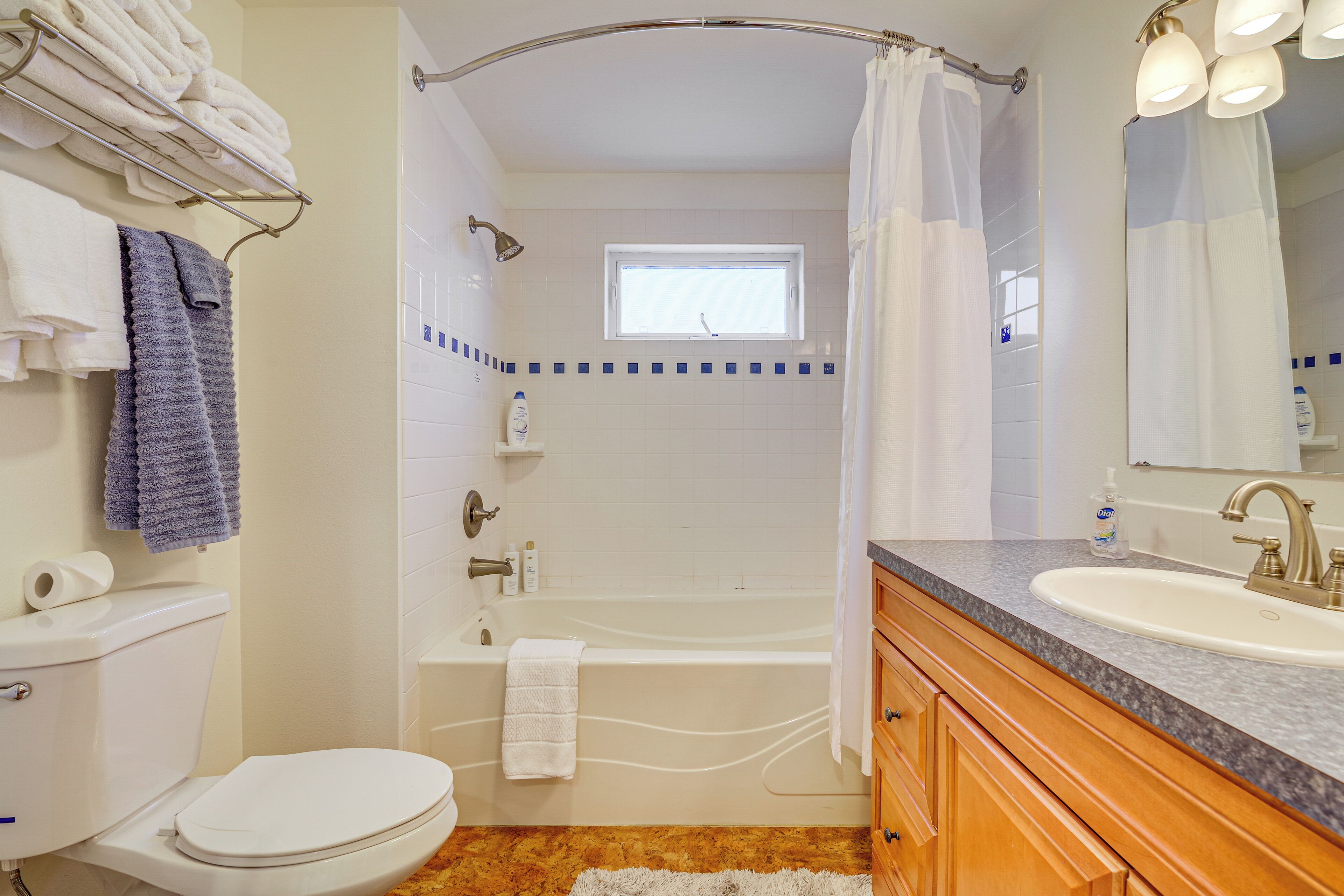 Ein Badezimmer mit Toilette, Waschbecken, Badewanne und Duschvorhang.