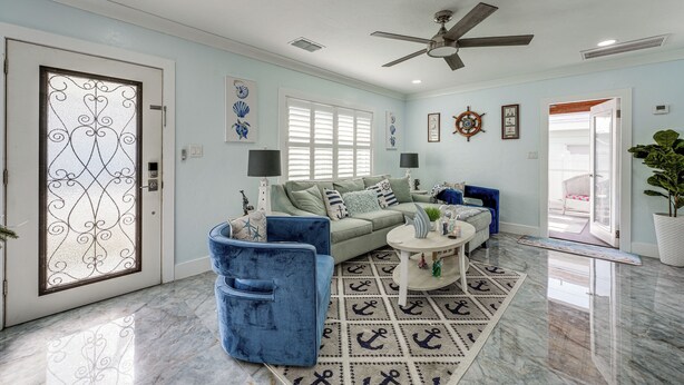 A spacious living room with a sofa, armchairs, and a coffee table. - Steps to Madeira Beach! Modern Family Getaway (Madeira Beach)