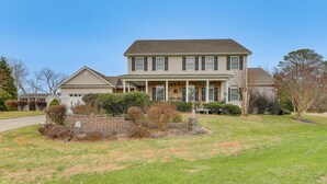 A two-story house with a front porch, a brick foundation, and a well-maintained lawn. - 2 Mi to Bethany Beach! Spacious Family Retreat (Ocean View)